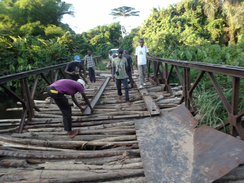 “Distribution team sets an iron ledge over unstable bridge to help people cross by foot.” Photo and caption courtesy of AMF.